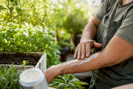 Hands applying mosquito balm in garden